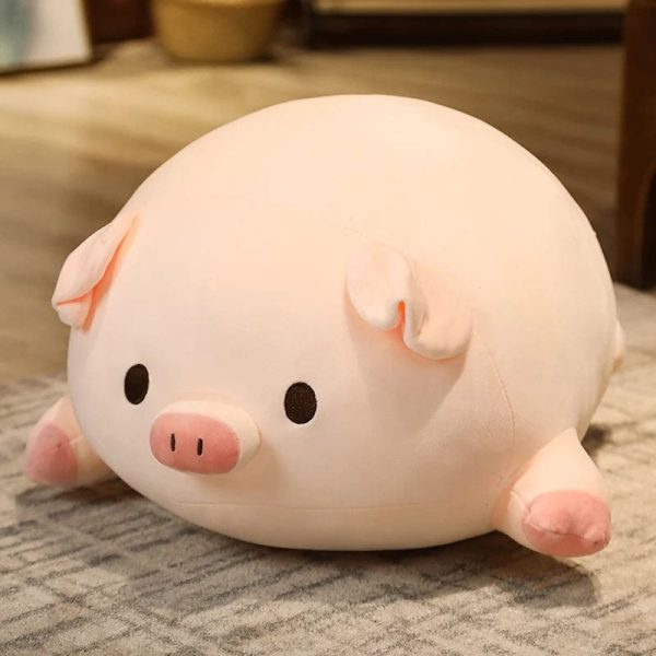 peluche cochon aux yeux ouverts allongé